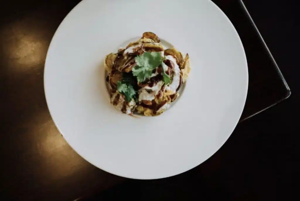 An overhead shot of a white dish with a fancy plated appetizer in the middle