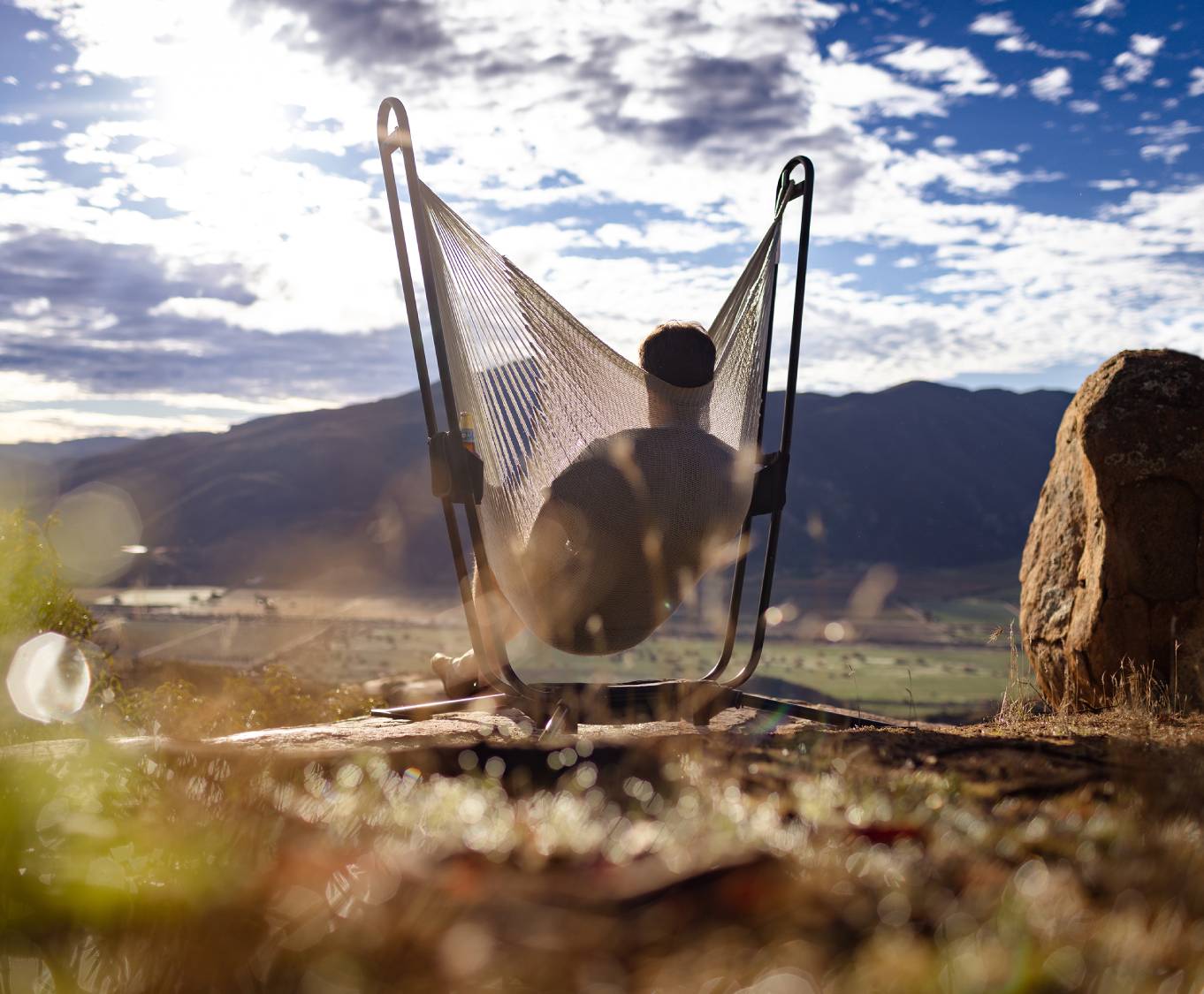 A picture of a man in a hammock that is outside